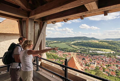 Zwei Wanderer genießen den Ausblick vom Turm der Burg Normannstein auf Treffurt und das Werratal
