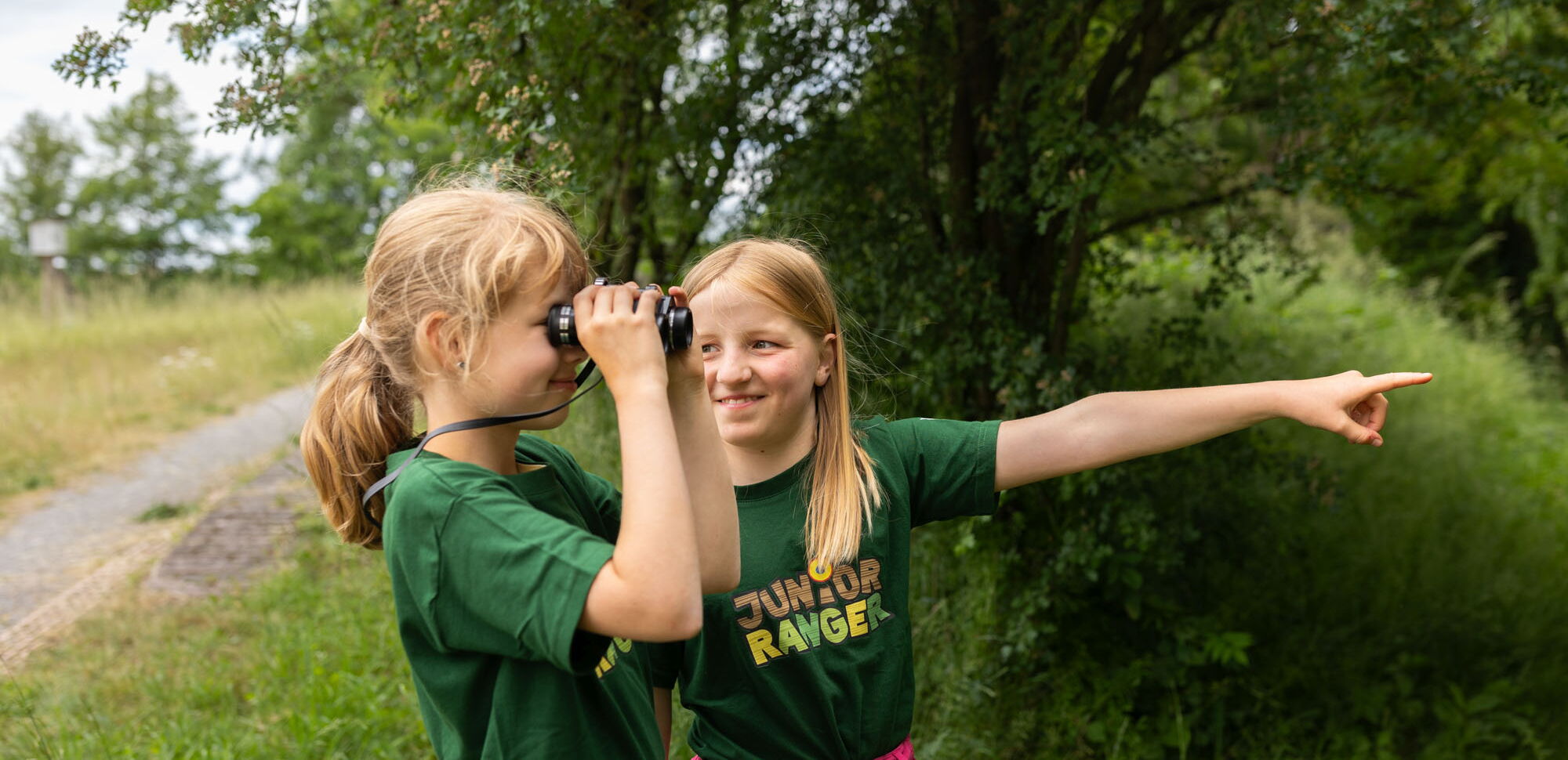 Zwei Mädchen mit Fernglas im Naturpark Eichsfeld Hainich Werratal