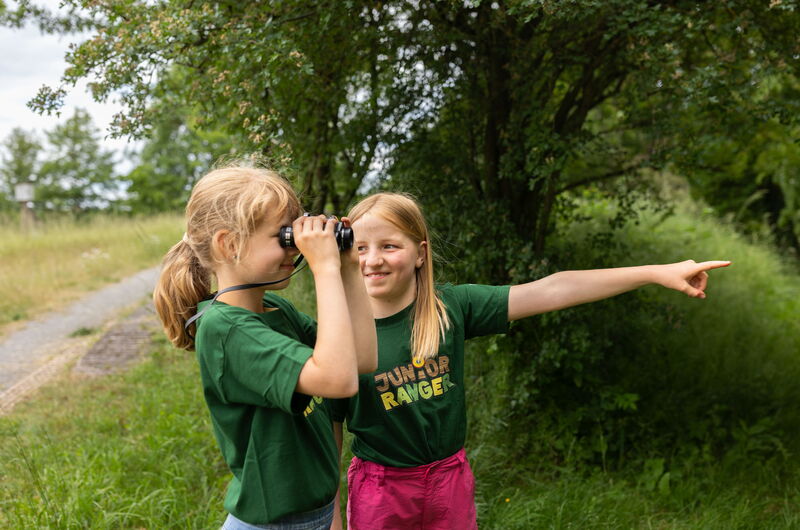 Zwei Mädchen mit Fernglas im Naturpark Eichsfeld Hainich Werratal